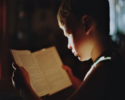 student reading notes in soft light