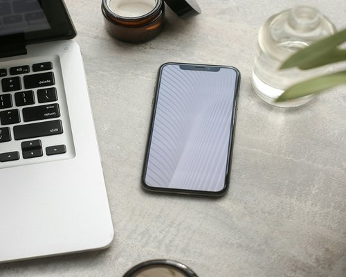 phone notebook and water on a work desk